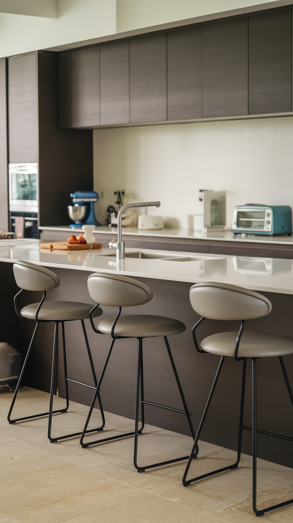 A modern kitchen featuring contemporary bucket seat bar stools with a neutral color palette and a sleek design.
